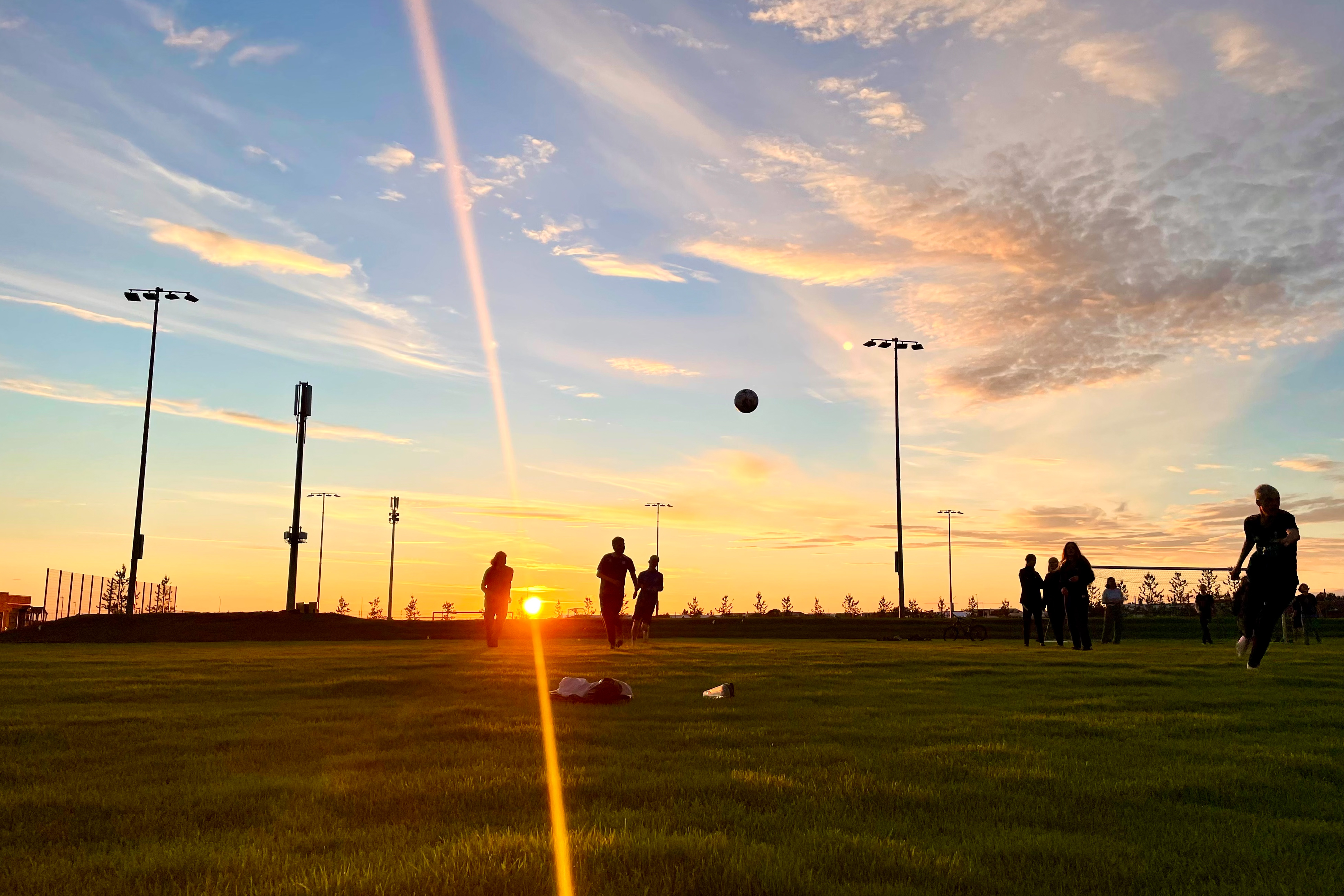 Photo of students playing soccer at sunset
