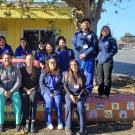 A group of about a dozen students posing for a photo in front of a community building in Knights Landing, CA