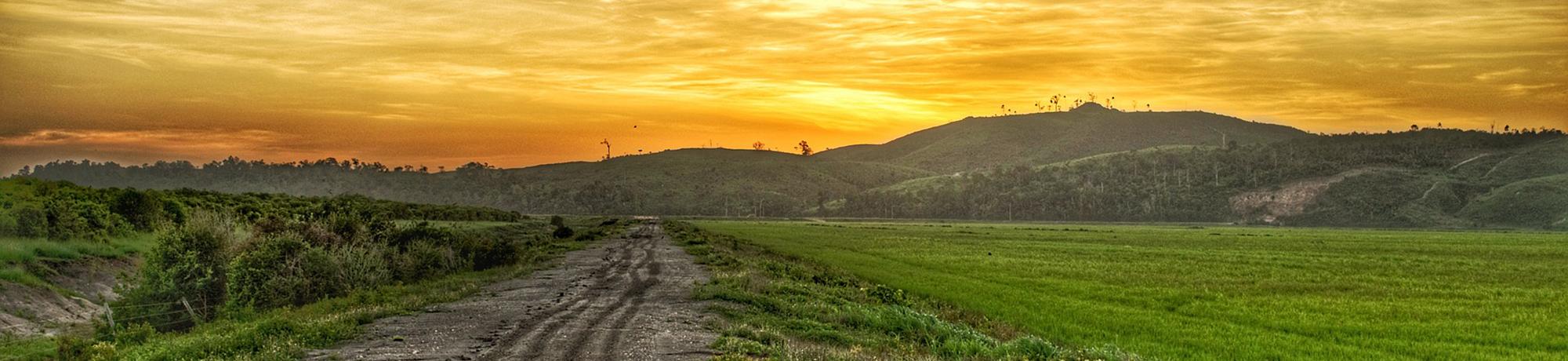 photo of a landscape with rolling hills and sunset sky